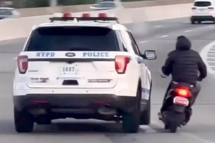 An NYPD SUV is seen repeatedly veering toward a moped on the Van Wyck Expressway in a video posted to Reddit Wednesday.